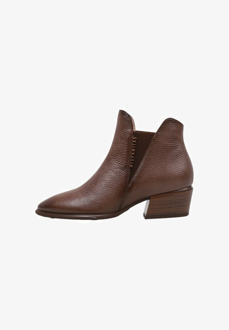 Bota de cuero marrón hasta el tobillo con punta afilada, superficie texturizada, goring lateral y tacón de madera gruesa.