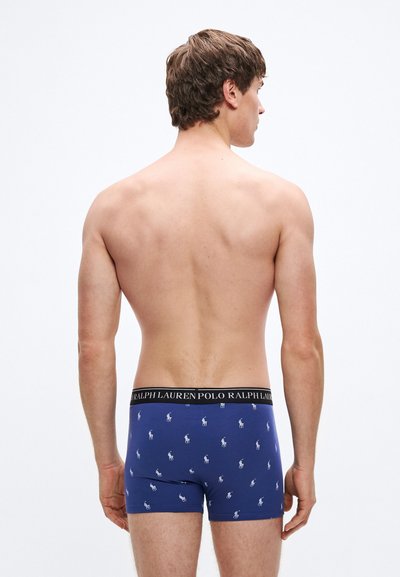 Tengerészkék boxeralsó nyomott fehér póló játékos mintával, fekete derékpánttal, amelyen a "RALPH LAUREN POLO" felirat található.