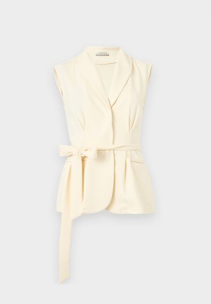 Bezrekawna kremowa kamizelka w stylu żakietu z szerokimi klapami i wiązanym paskiem w talii, wyposażona w jedną kieszeń na piersi i dopasowany krój.