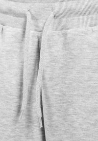 Grijze katoenen sweatpants met een geribbelde elastische tailleband en trekkoord, voorzien van een zachte textuur en subtiel gemêleerd patroon.
