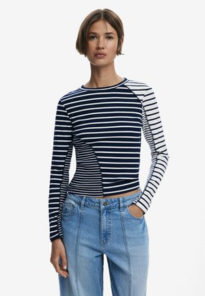Langärmliges gestreiftes Hemd in Marineblau und Weiß, mit einem farblich abgestimmten Design und unterschiedlich breiten Streifen in passender Form. Aus Baumwollmischung.