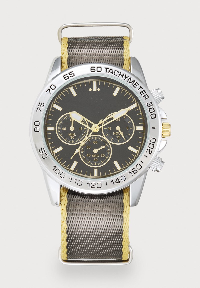 Chronografur med sort urskive, sølv bezel, gule detaljer og et struktureret gråt stofarmbånd. Har tachymeter og flere subskiver.