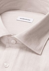 Collo della camicia in beige con motivo a spina di pesce e una texture tessuta, dotato di bottoni bianchi e un'etichetta con il testo "seidensticker".
