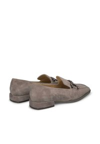 Graue Wildlederslipper mit niedrigem Quadratabsatz, ausgestattet mit einem dekorativen Riemen mit metallischen Akzenten und einem offenen Design an der Oberseite.