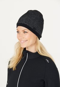 Sort strikket hue med en struktureret finish, der har en ribbet manchet. Stoffet inkluderer subtile lysaccenter og et lille logo-tag.
