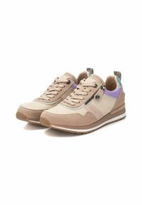Zapatillas beige con una mezcla de materiales de ante y malla. Presentan un acento púrpura, cremallera lateral y suela acolchada con un dibujo de goma.