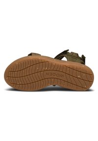 Gröna textilsandaler med justerbara remmar, strukturerad gummisula och vågig mönstring på sulan. "WODEN"-logotypen präglad på sulan.