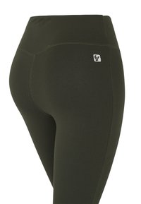 Leggings de tiro alto en verde oliva oscuro, hechos de un tejido elástico y suave. Presentan costuras discretas y un pequeño parche con el logo cerca de la cintura.