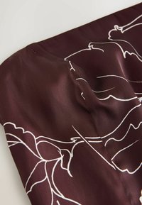 Material satinat de culoare burgundy intens, cu contururi albe florale. Designul prezintă o textură netedă și o cusătură curată la margine.