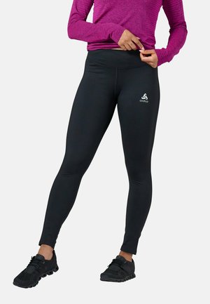 Black leggings with a high waistband, featuring a subtle logo on the left hip. Made from stretchy material with a smooth texture.