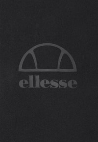 Logotipo de la marca Ellesse que presenta un semicírculo con dos segmentos laterales sobre la palabra "ellesse" en un fondo de tela negra.