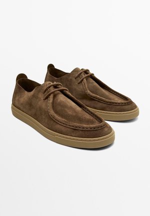 Braune Wildleder-Sneaker mit Schnürung und beigen Gummisohlen, ausgestattet mit Mokassin-ähnlichen Nähten und abgerundetem Zehendesign.