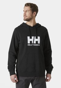 Sudadera negra con capucha, con un bolsillo tipo canguro en la parte frontal y un gran logo blanco "HH", hecha de un tejido suave, con puños y dobladillo acanalados.