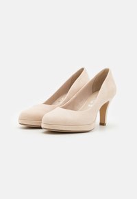 Décolleté in suede beige con punta arrotondata e un sottile plateau. Il tacco è slim e misura circa 7,5 cm. Tessuto liscio e design pulito.