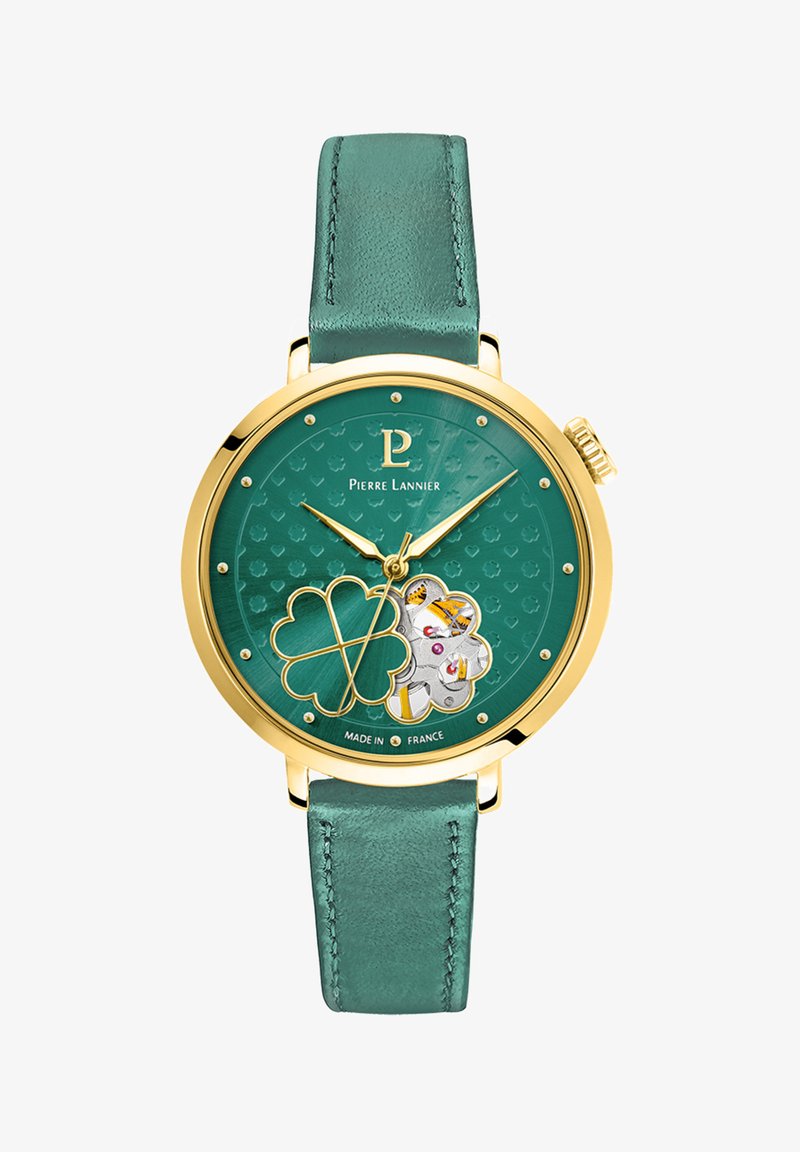 Grønt læderrem ur med guldfarvet hus, struktureret teal urskive, kløvermotiv og flere dekorationselementer.