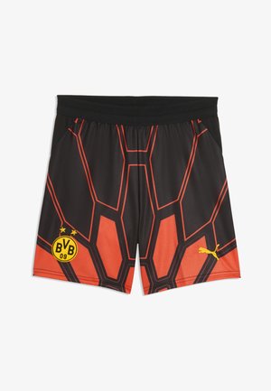 Pantalones cortos deportivos negros y naranjas con patrón geométrico, logo de Borussia Dortmund en la pierna izquierda, y logo amarillo de Puma en la pierna derecha.
