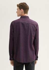 Long-sleeve shirt in dark purple fabric with a textured weave, featuring a curved hem and buttoned cuffs. Back view shows a classic collar.