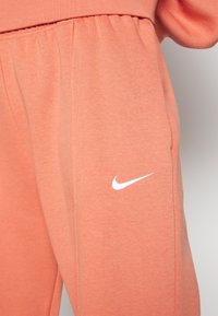 Nike Sportswear W NSW ESSNTL PANT FLC TREND - Calças de fato de treino - madder root/white