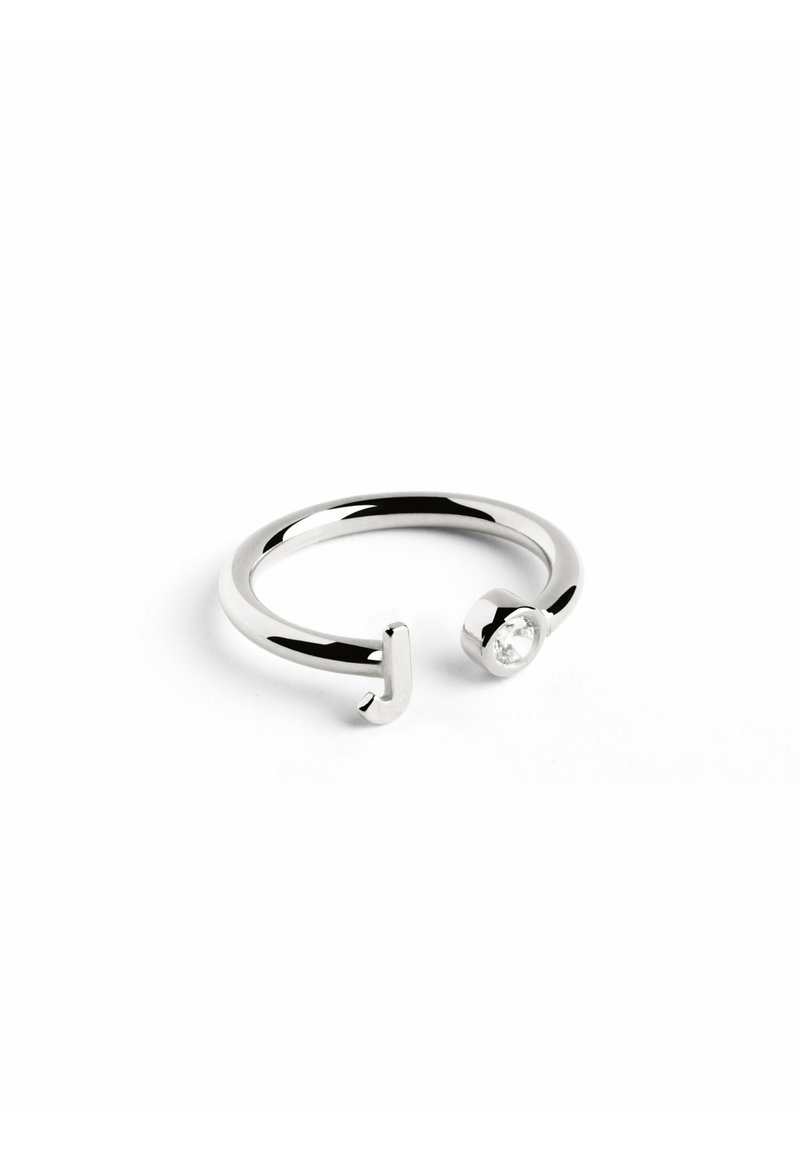 Anillo de plata abierto que presenta una pequeña piedra preciosa clara en un extremo y una forma de "J" vertical en el extremo opuesto.