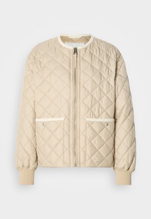 Beige steppelt bomber dzseki elöl cipzárral, két oldalzsebbel, fehér díszítéssel, valamint bordázott mandzsettákkal a hüvelyeken és az alján.