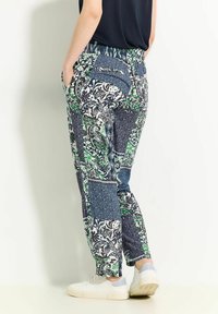 Pantalons à motifs en tissu léger présentant un design en patchwork de bleu marine, vert et blanc, dotés d'une taille élastique et de poches latérales.