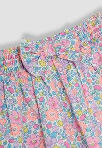 Lengvi medvilniniai šortai su pastelinių spalvų gėlių raštu, kuriame yra rožinių, violetinių ir mėlynų gėlių. Elastinga juosmens juosta su mazgo detale.