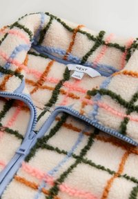 Fleece zip-up jacket in cream with a colorful plaid pattern featuring blue, pink, green, and orange. Includes a light blue zipper.