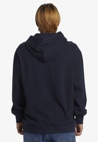 Sudadera con capucha de color azul marino, corte holgado, puños y dobladillo acanalados. Cuenta con una capucha espaciosa y una textura de tela suave.