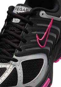 Scarpa sportiva nera e grigia con tomaia in mesh e sintetico, dettagli rosa, suola testurizzata e logo Nike in evidenza cucito in rosa.