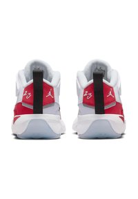 Des chaussures de sport rouge et blanches avec une tige en mesh, des accents texturés, un onglet de talon proéminent et le numéro "23" brodé à l'arrière.