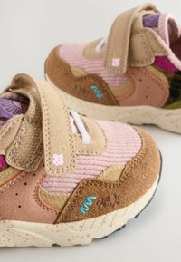 Dziecięce sneakersy w różowych i brązowych odcieniach z rzepami, dekoracyjnym przeszyciem i pastelowymi akcentami na białych nakrapianych podeszwach.