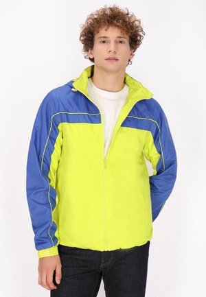 Let jacket i lys gul og blå, med lynlås foran, høj krave, elastiske manchetter og kontrasterende sideliner.