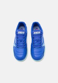 Para niebieskich halówek piłkarskich Joma Dribling z sznurowadłami, białym logo i jasnoniebieskimi podeszwami, widziana z góry na jasnym tle.