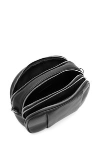 Bolso de cuero negro con tres secciones con cremallera, que presenta una superficie texturizada y herrajes plateados en contraste. Diseño compacto y rectangular.