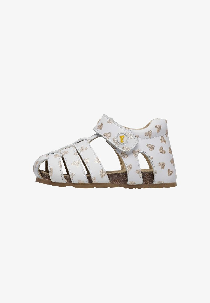 White sandals with gold heart pattern, three front straps, a side Velcro strap, and a sturdy, textured brown sole.