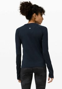 Langärmliges Sportoberteil in Marineblau aus anliegendem Material, mit Rundhalsausschnitt und kleinem Logo im oberen Rückenbereich.