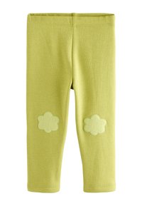 Grüne Baumwoll-Leggings mit elastischem Bund, versehen mit zwei strukturierten, blumenförmigen Applikationen im Kniebereich. Glatte Oberfläche.