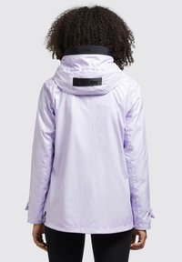 Jachetă de culoare violet deschis, cu glugă, confecționată dintr-un material lucios. Are un patch cu un logo negru pe guler și mansete de mână ajustabile.
