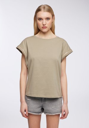 T-shirt a maniche corte di colore verde oliva chiaro, realizzato in cotone, con dettagli in filo metallico sulle maniche arrotolate e una silhouette rilassata.