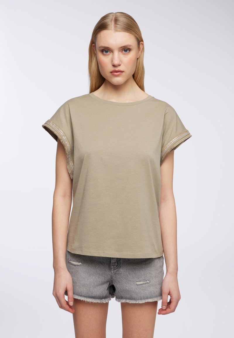 T-shirt a maniche corte di colore verde oliva chiaro, realizzato in cotone, con dettagli in filo metallico sulle maniche arrotolate e una silhouette rilassata.