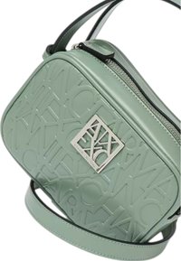 Borsa a mano in pelle verde con texture, logo in rilievo, forma rettangolare, dettagli in argento, tracolla regolabile e chiusura con zip.