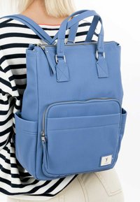 Blue nylon backpack with dual top handles, a zippered main compartment, front pocket, and side pockets. Features ribbed texture and silver hardware.