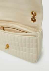 Borsa a tracolla beige trapuntata con finitura in pelle liscia, accessori in oro e una tasca interna con zip, caratterizzata da un dettaglio di chiusura a scatto.