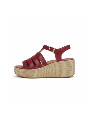 Red leather wedge sandal with multiple straps, ankle buckle, and woven platform sole in beige.