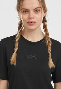 Black cotton T-shirt with short sleeves and crew neck. Features embroidered "O'Neill" logo in gray on the chest area. Smooth texture.