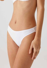 Witte katoenen bikini slipjes met een eenvoudig ontwerp, zachte textuur en een lage taille voor comfort en pasvorm. Geen zichtbare patronen of hardware.
