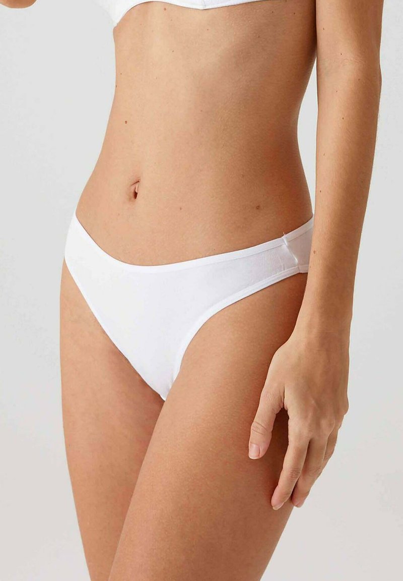 Witte katoenen bikini slipjes met een eenvoudig ontwerp, zachte textuur en een lage taille voor comfort en pasvorm. Geen zichtbare patronen of hardware.
