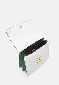 Pehmustettu valkoinen nahkalaukku kultaisella lukolla, jossa vihreä käärmeenahkainen sisävuori ja useita lokeroita järjestelyä varten.