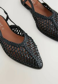 Juodos pintos slingback bateliai su smailiu pirštu, turintys tekstūruotą viršutinę dalį ir rudą vidpadį, sukurti užtikrinti tvirtą prigludimą.