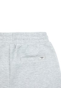 Grijze sweatpants met een elastische tailleband en een achterzak, voorzien van een klein label met de tekst "Chelsea Peers." Zacht, gestructureerd materiaal.